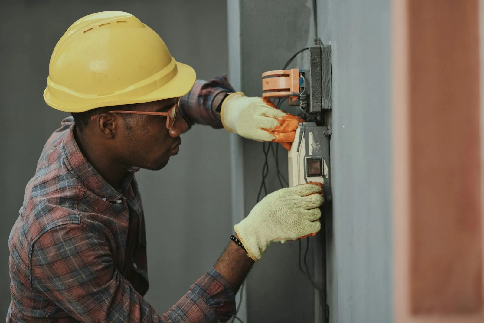 HVAC technician in a hard hat servicing equipment