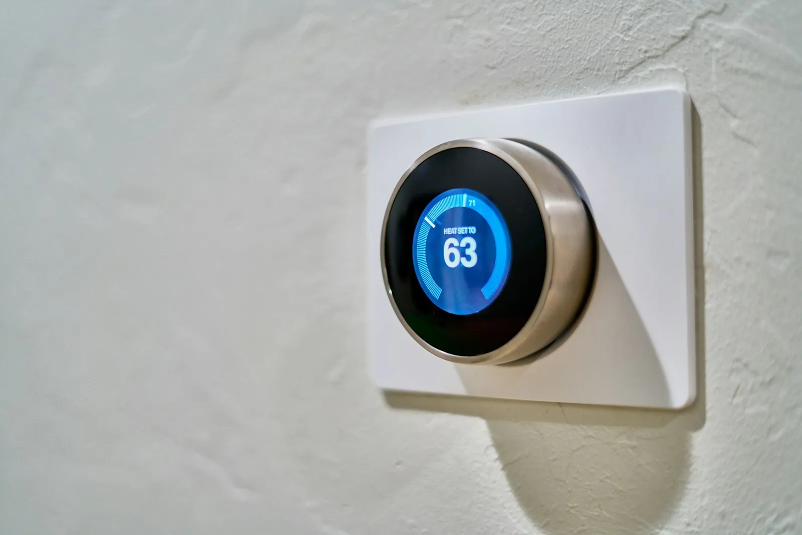 Smart thermostat on a wall set to 63 degrees