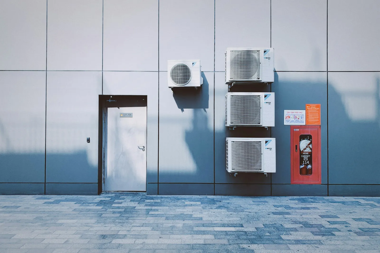 Four air conditioning units mounted on an exterior wall
