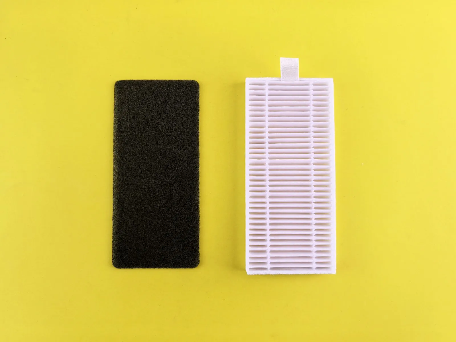A clean air filter beside a dirty clogged air filter