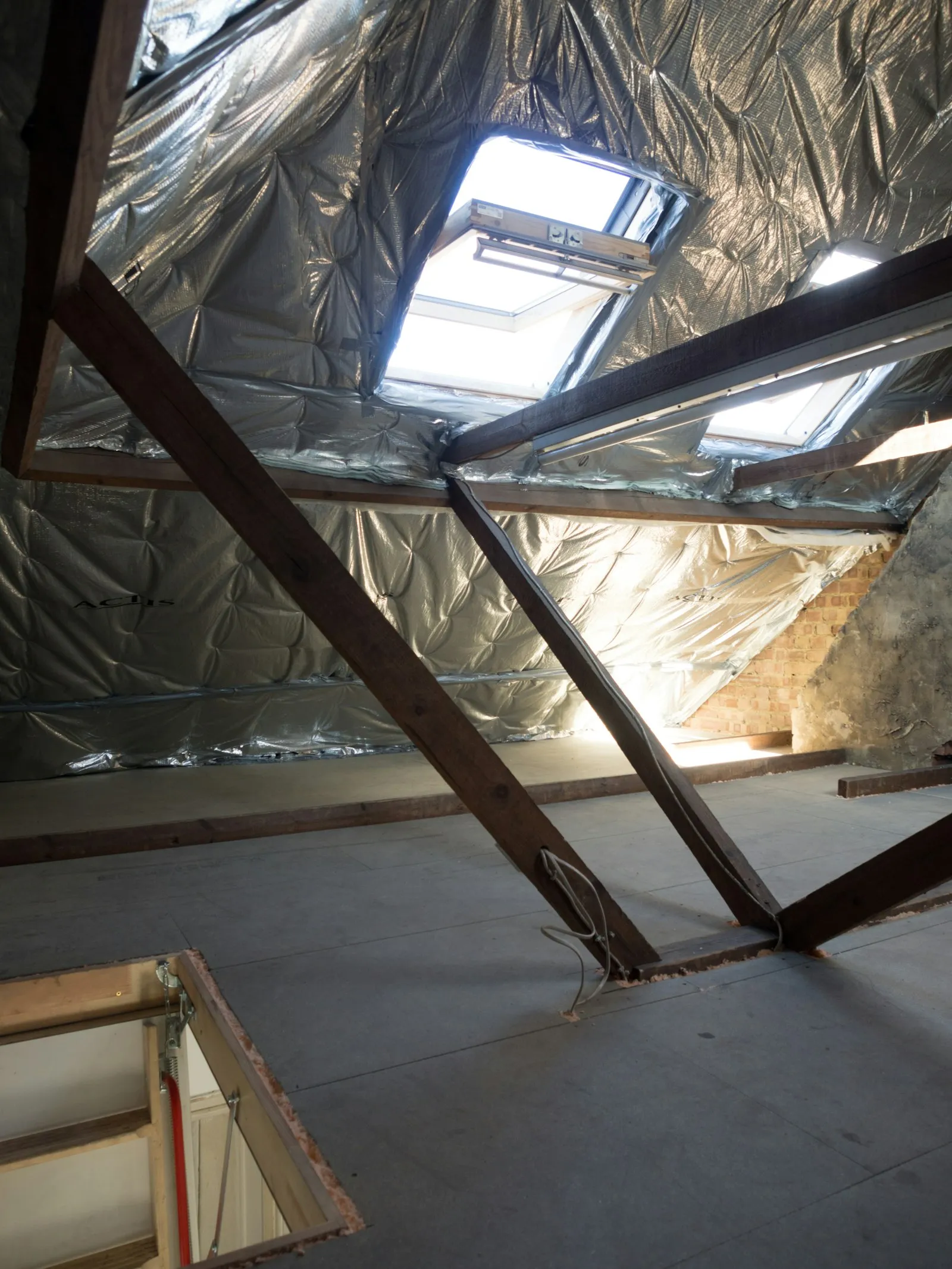 Attic space with blown insulation and skylights