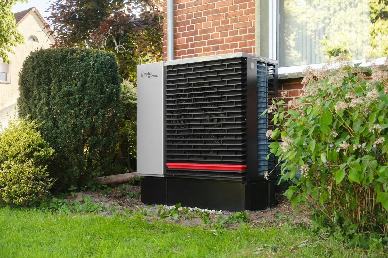 Outdoor heat pump unit beside a brick building